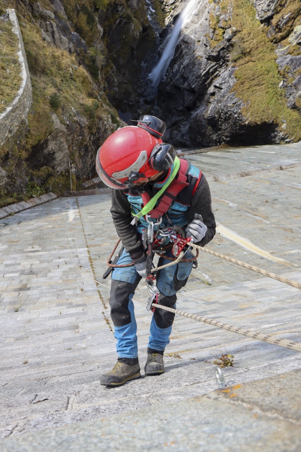 Cordiste équipé d'un casque et d'un harnais de sécurité en paroi