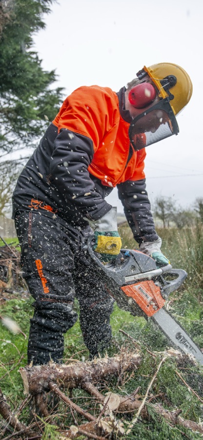 Bûcheron portant une veste de protection, tronçonneuse en action